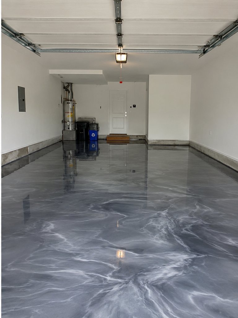The same garage floor after a high-gloss grey metallic epoxy coating by Wish Coatings